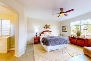a bedroom with a bed and a ceiling fan at Pink Mountain Retreat in Tucson