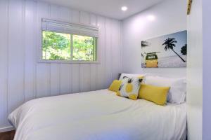a white bedroom with a large bed with yellow pillows at Waterfront - Chalet des Becassines in Nominingue