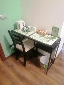 a black desk with a chair and a table at BGY Airport Guesthouse in Orio al Serio