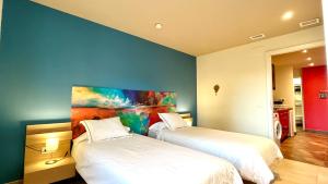 Habitación con 2 camas y una pintura en la pared. en Appartment Pinar, en Málaga