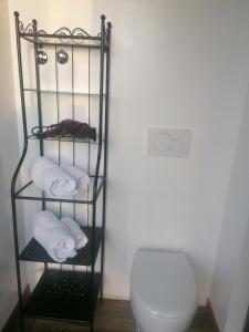 a towel rack with towels and a toilet in a bathroom at BGY Airport Guesthouse in Orio al Serio