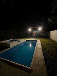 una piscina en un patio por la noche en Hermosa y amplia casa en Roldán en Roldán