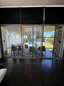 ein Wohnzimmer mit großen Glastüren und einem Tisch in der Unterkunft Hermosa y amplia casa en Roldán in Roldán