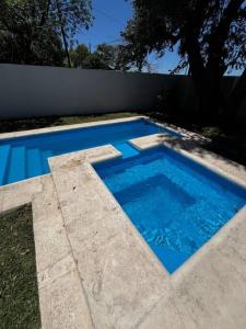 una piscina de agua azul en un patio en Hermosa y amplia casa en Roldán en Roldán
