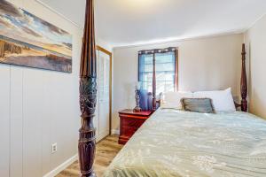 a bedroom with a bed with a wooden post at The Cozy Cottage by the Ocean in Hampton