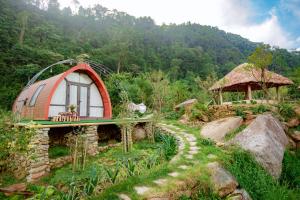 una pequeña casa con techo rojo en una montaña en Ngũ Chỉ Sơn Trekking Sapa en Sa Pa