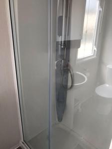 a shower with a glass door next to a sink at Beautiful sea view 3 bedroomed Holiday Home Caravan in Exmouth