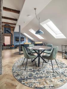 a dining room with a table and chairs on a rug at Cozy Penthouse in Vilnius