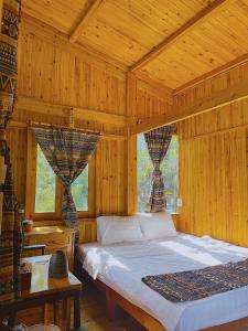 1 dormitorio con 1 cama en una habitación de madera en Ngũ Chỉ Sơn Trekking Sapa en Sa Pa