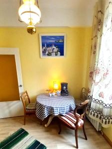 um quarto com uma mesa com um candeeiro em Majakovski Guesthouse em Sillamäe