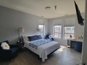 a bedroom with a bed and a chair and windows at Blue Oasis in Dearborn