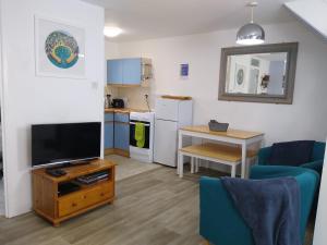 a living room with a television and a kitchen at Three bed Holiday Home in Hayle