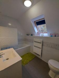 a bathroom with a sink toilet and a window at Les Suites de Véronique, chez Véronique Olive in Saint-Pair-sur-Mer