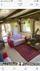 uma sala de estar com um sofá roxo e uma lareira em The Old Smithy, Ullswater em Glenridding