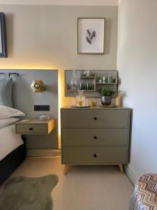 sypialnia z komodą i łóżkiem z szafką nocną w obiekcie Cosy Room In Altrincham w mieście Hale