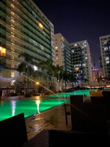 uma piscina com luzes verdes numa cidade à noite em Casa Renta by John J. em Manila