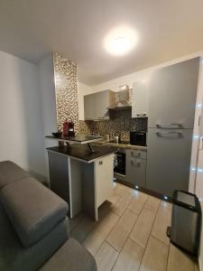 een keuken met een wastafel en een bank in een kamer bij Apt cosy village olympique in Saint-Ouen