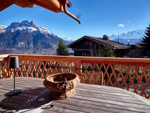 una mesa con una cesta en una terraza de madera con montañas en Chalet d'Anselme, en Cordon