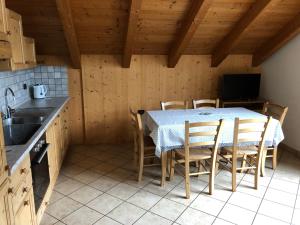 cocina con mesa, sillas y fregadero en Casa Vacanze Sablonera, en Bormio