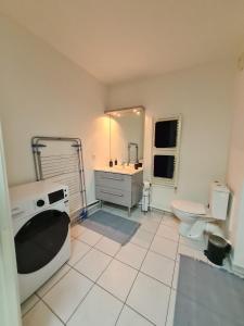 een badkamer met een wastafel en een wasmachine bij Apt cosy village olympique in Saint-Ouen