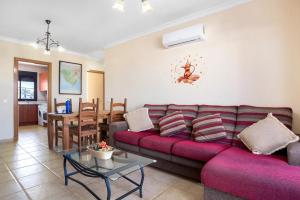a living room with a red couch and a table at Apart 2ª Pl Coto de Santi Petri 432 in Chiclana de la Frontera
