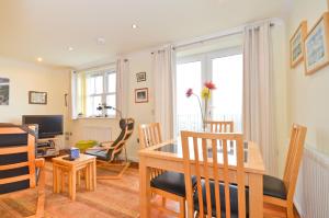 a dining room and living room with a table and chairs at Stunning Ocean Views, The Priory in Shanklin