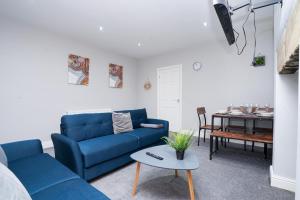 a living room with a blue couch and a table at Beautiful House with Parking in Wibsey