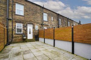 a brick building with a fence and a white door at Beautiful House with Parking in Wibsey