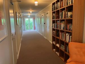 a hallway with a book shelf with books at Bogesund Slottsvandrarhem in Vaxholm