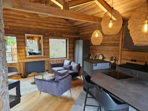 ein Wohnzimmer mit Holzwänden sowie einem Tisch und Stühlen in der Unterkunft Bois des Alpes in Annecy