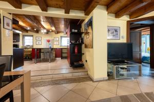 ein großes Wohnzimmer mit einem großen TV und einem Tisch in der Unterkunft Alpine Apartment in Aosta