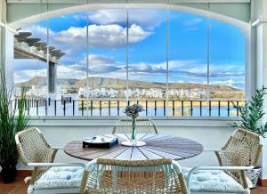 une terrasse avec une table et des chaises ainsi qu'une grande fenêtre. dans l'établissement Hacienda Riquelme Golf Resort Fantastic Apartment, à Sucina