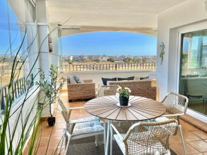 un patio avec une table et des chaises sur un balcon dans l'établissement Hacienda Riquelme Golf Resort Fantastic Apartment, à Sucina