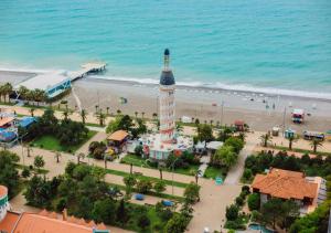 eine Luftansicht auf einen Strand mit einem Uhrturm in der Unterkunft KING DAVID & Orbi City Batumi in Batumi
