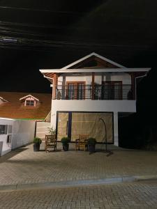 a house with a balcony on top of it at Apartamento Avenida in Camanducaia