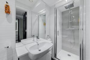 y baño blanco con lavabo y ducha. en Mornington Hotel London Victoria, en Londres