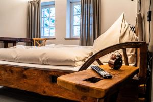 Schlafzimmer mit einem Bett und einem Tisch mit Fernbedienung in der Unterkunft Ferienwohnung "Stellmacherei" in Versmold