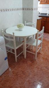 a white table and chairs with a bowl of flowers on it at APARTAMENTO PLAYA AZUL in Rincón de la Victoria