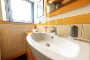 een badkamer met een witte wastafel en een spiegel bij Alpine Apartment in Aosta +21 foto's