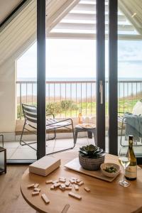 a living room with a table with a bottle of wine at The Penthouse in Hope-Cove