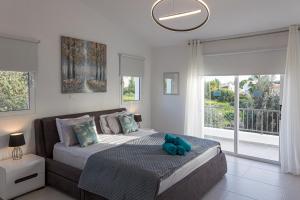 a bedroom with a bed with a teddy bear on it at Grand Villa Baci in Coral Bay