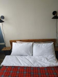 Apartment Milena Tbilisi Onebedroom في تبليسي: سرير بشرشف ووسائد بيضاء في الغرفة