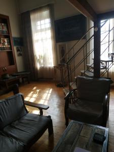 Apartment Milena Tbilisi Onebedroom في تبليسي: غرفة معيشة بها أريكة وكراسي ودرج