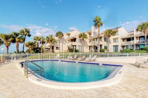 una piscina di fronte a un edificio con palme di Sonrisa 5 a Clearwater Beach