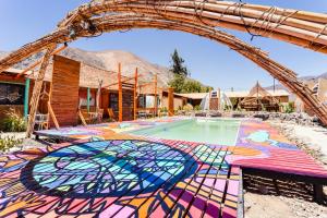 uma piscina com um piso colorido em mosaico e um arco em Hostal Cosmo Elqui em Rivadavia