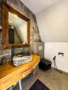 bagno con bancone in legno e specchio di Ultra house a Ilʼtsya Gurny