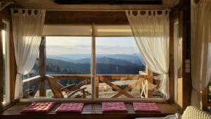 a room with a large window with a view of the mountains at Tiny House Casuta Schiorului 2, Mărișel Apuseni in Mărişel +15 photos