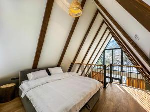 a bedroom with a bed and a large window at Ultra house in Ilʼtsya Gurny