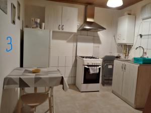 a kitchen with white cabinets and a table and a stove at Old Town Studio in Braşov