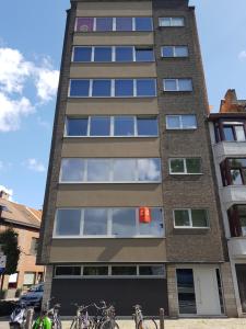 a tall building with bikes parked in front of it at Astrid - apartments in Mechelen